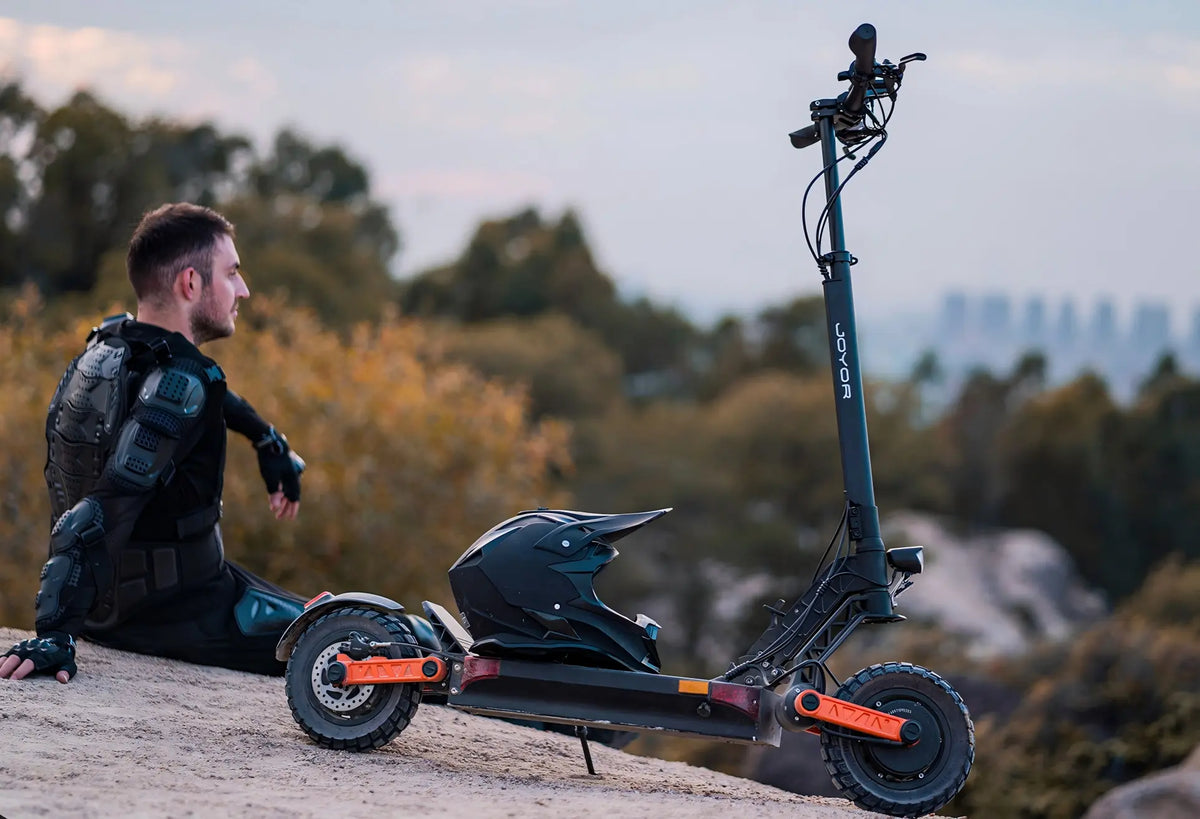 Video laden: Video showing male rider test Joyor S10-S-Z foldable electric scooter in natural mountain scenery